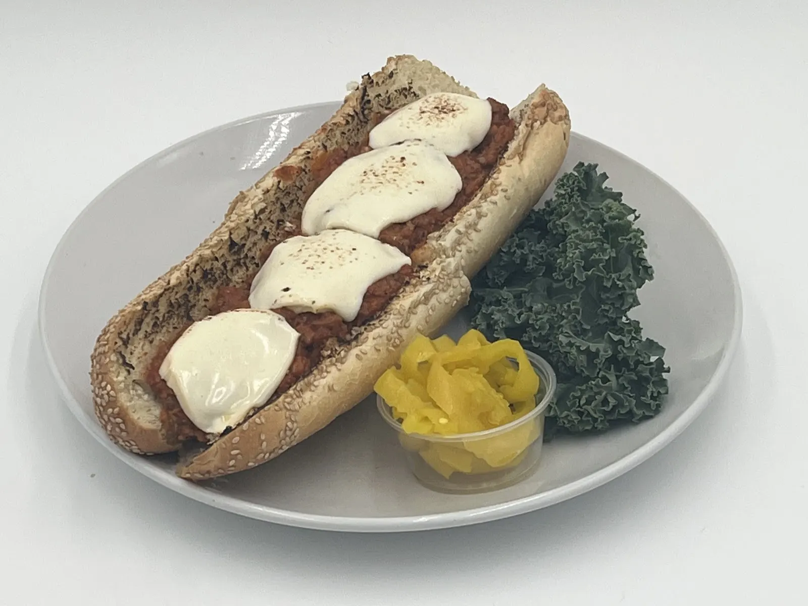 A meatball sandwich with melted cheese on a seeded Italian roll